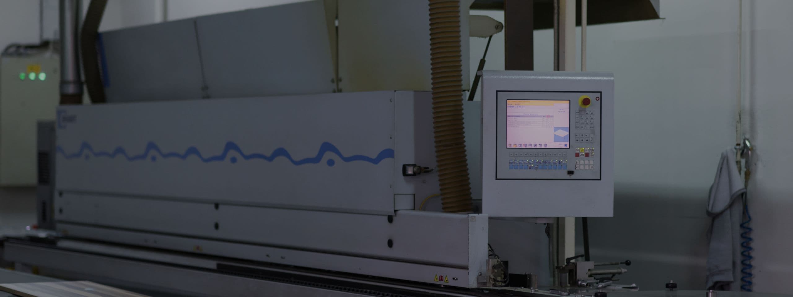 Large industrial manufacturing machine with digital control panel in a workshop